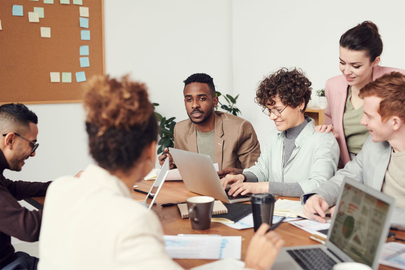 Professionals discussing their work around laptops in an office